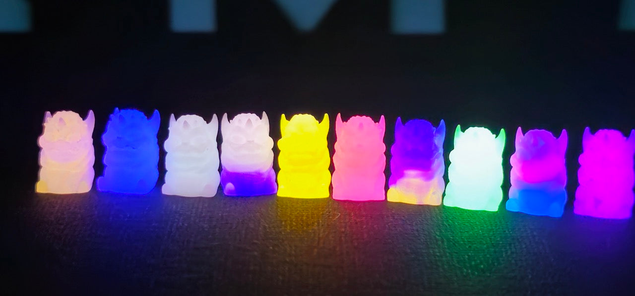 A blind box and art toy store presents: Little Shit Big Deal - Micro Steves resin figure. Limited edition, ships in 28 days. Row of colorful glowing figures, white and purple sculpture, pink and yellow object.
