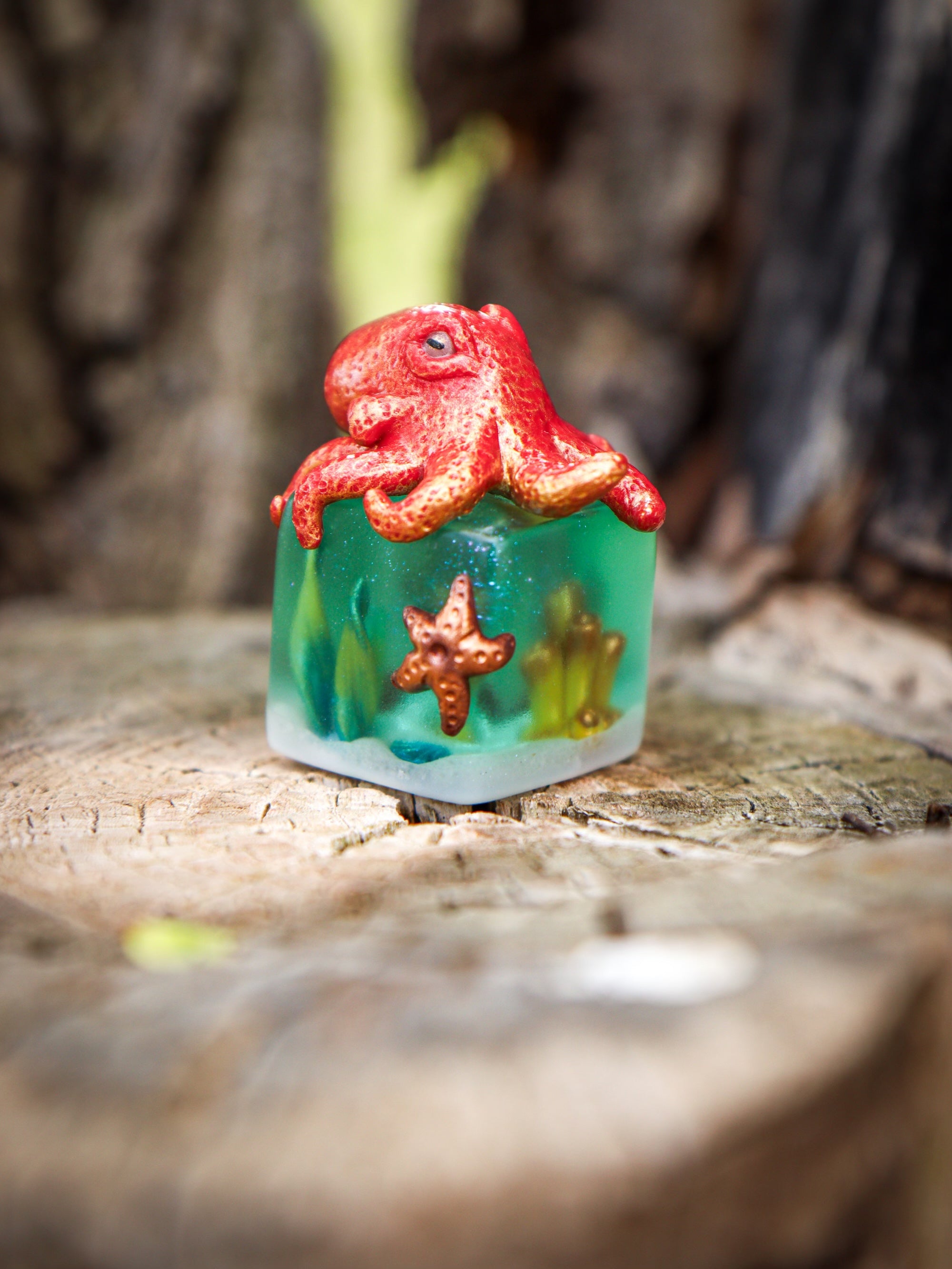 A whimsical toy sculpture titled Little Shit Big Deal - CUBES by Fairies And Fancies, featuring a small red octopus on a green cube. Sculpted by Dr. Polpz.