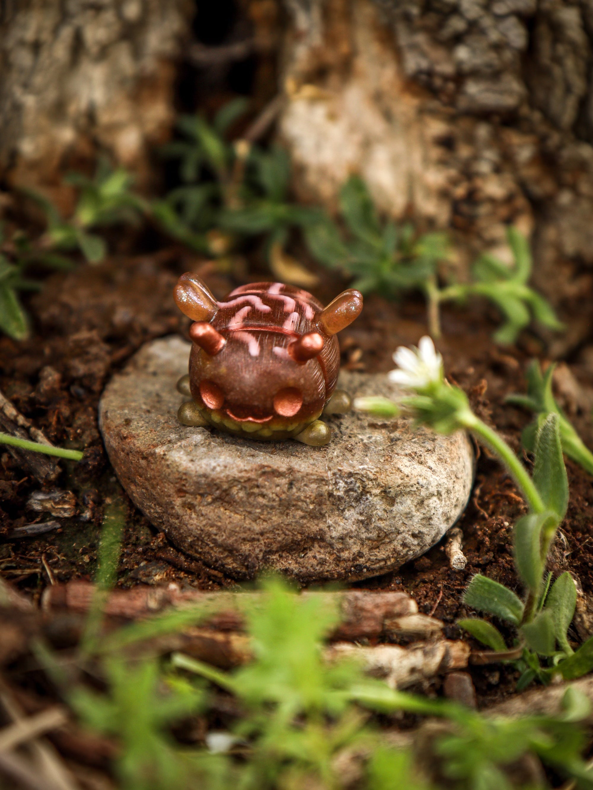 A small toy bug on a rock, part of the Octopus Cube collection by Fairies And Fancies at Strangecat Toys. Made of Polymer Clay and Resin, approximately 1 1/2 inches tall.