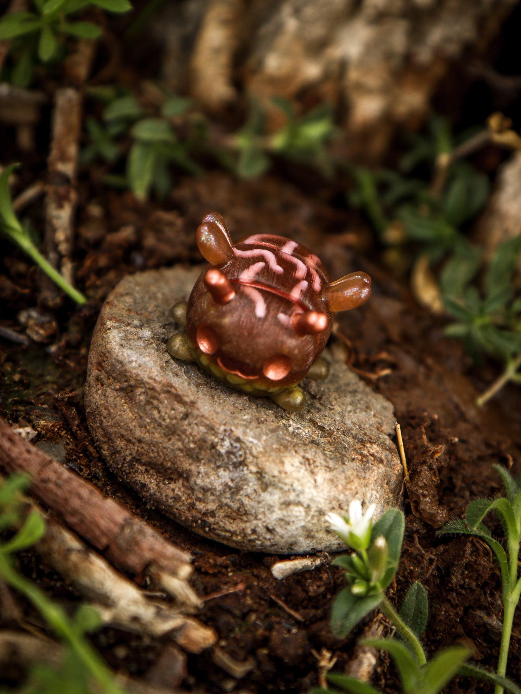A whimsical toy bug on a rock, part of the Octopus Cube collection by Fairies And Fancies at Strangecat Toys. Made of Polymer Clay and Resin, approximately 1 1/2 inches tall.