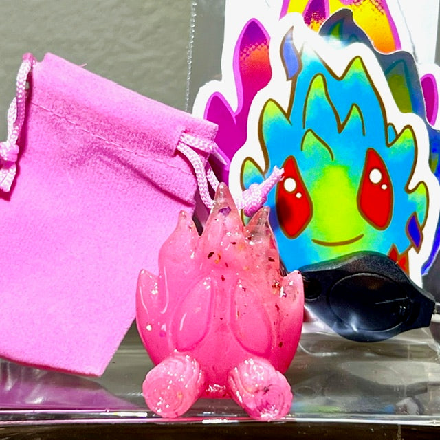 A pink toy with UV fluorescent pink gradient, rainbow beads, and translucent resin. Little Shit Big Deal - Ember by Leecifer. From Strangecat Toys, a blind box and art toy store.