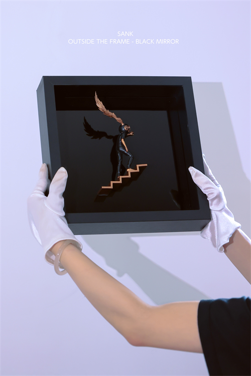 Sank - Outside the Frame: A matte black figurine ascends copper stairs in a black display frame, held by white-gloved hands, showcasing contemporary art toy design.