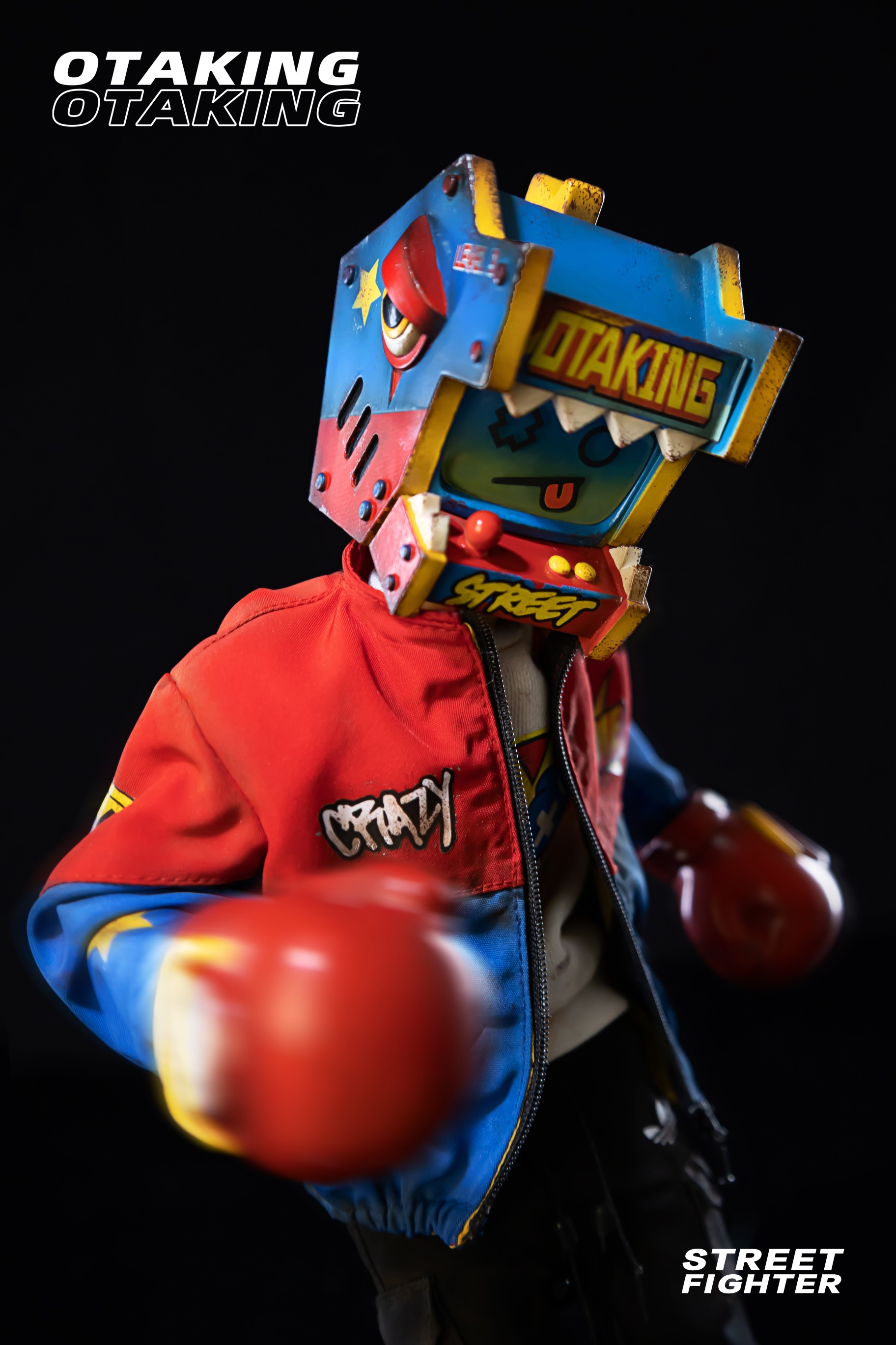 Person in OTAKING - Street fighter robot garment and mask, with logo and sign details, holding a toy.