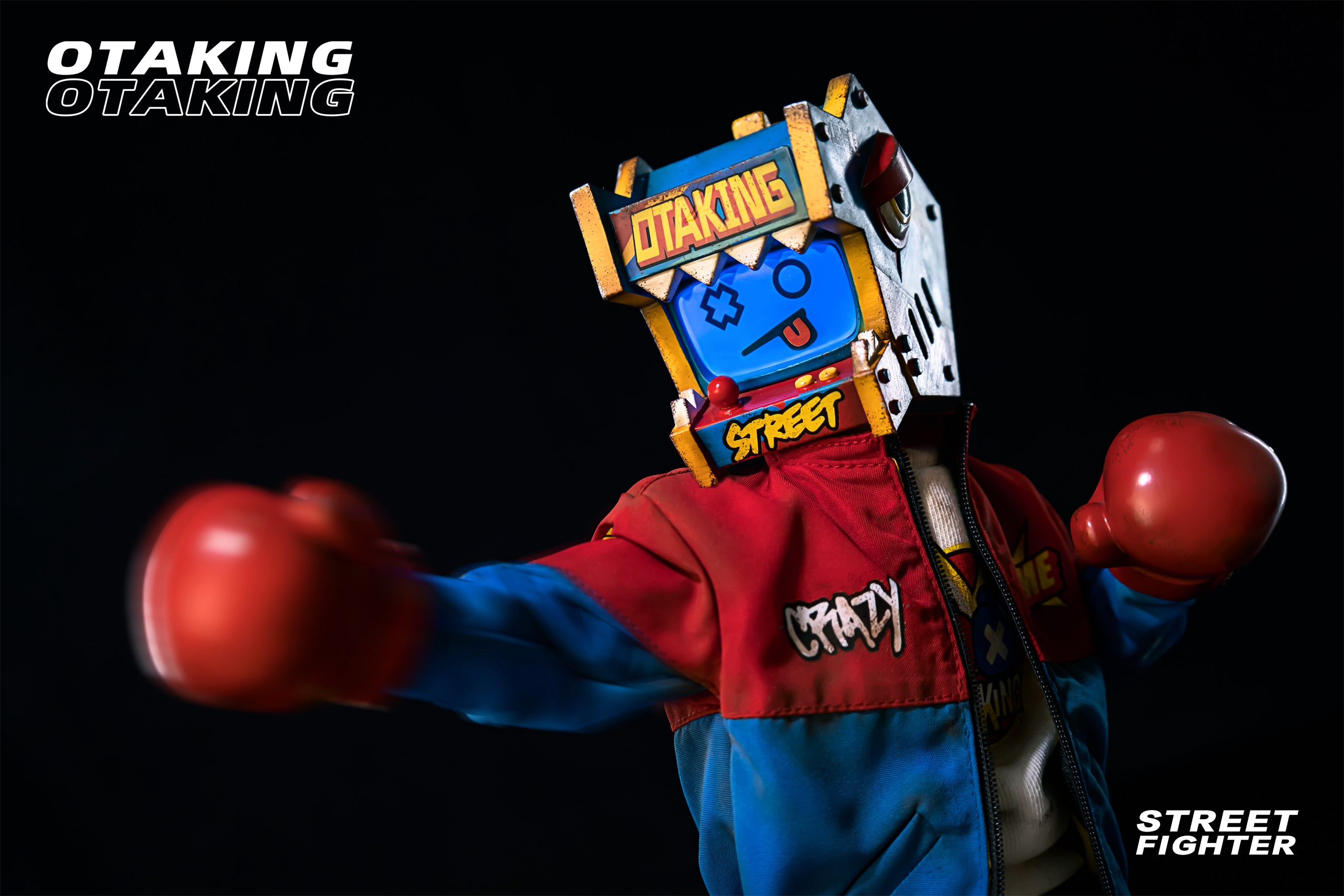 Person wearing OTAKING - Street fighter robot garment holding toy and graffiti on box.