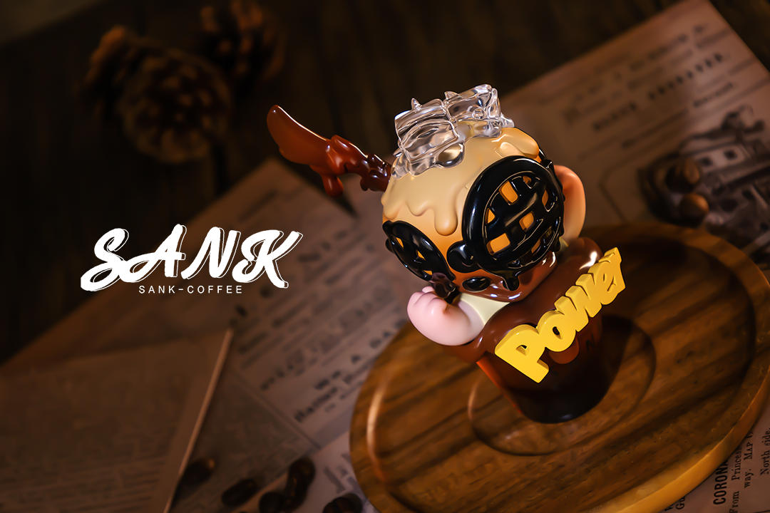 Alt text: Sank-Americano limited edition toy figurine in a small glass with brown liquid, available for preorder, ships Aug 2024.