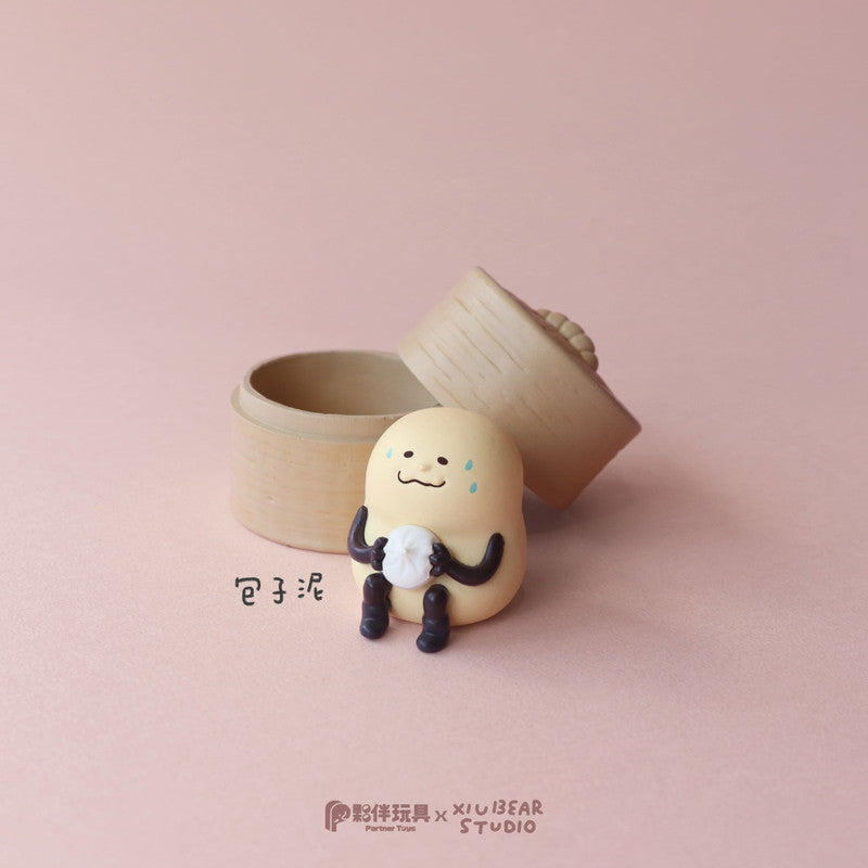 Yum Yum Time Blind Box Series: Collectible baozi figure with worried expression, holding a mini bun, in front of bamboo steamer.