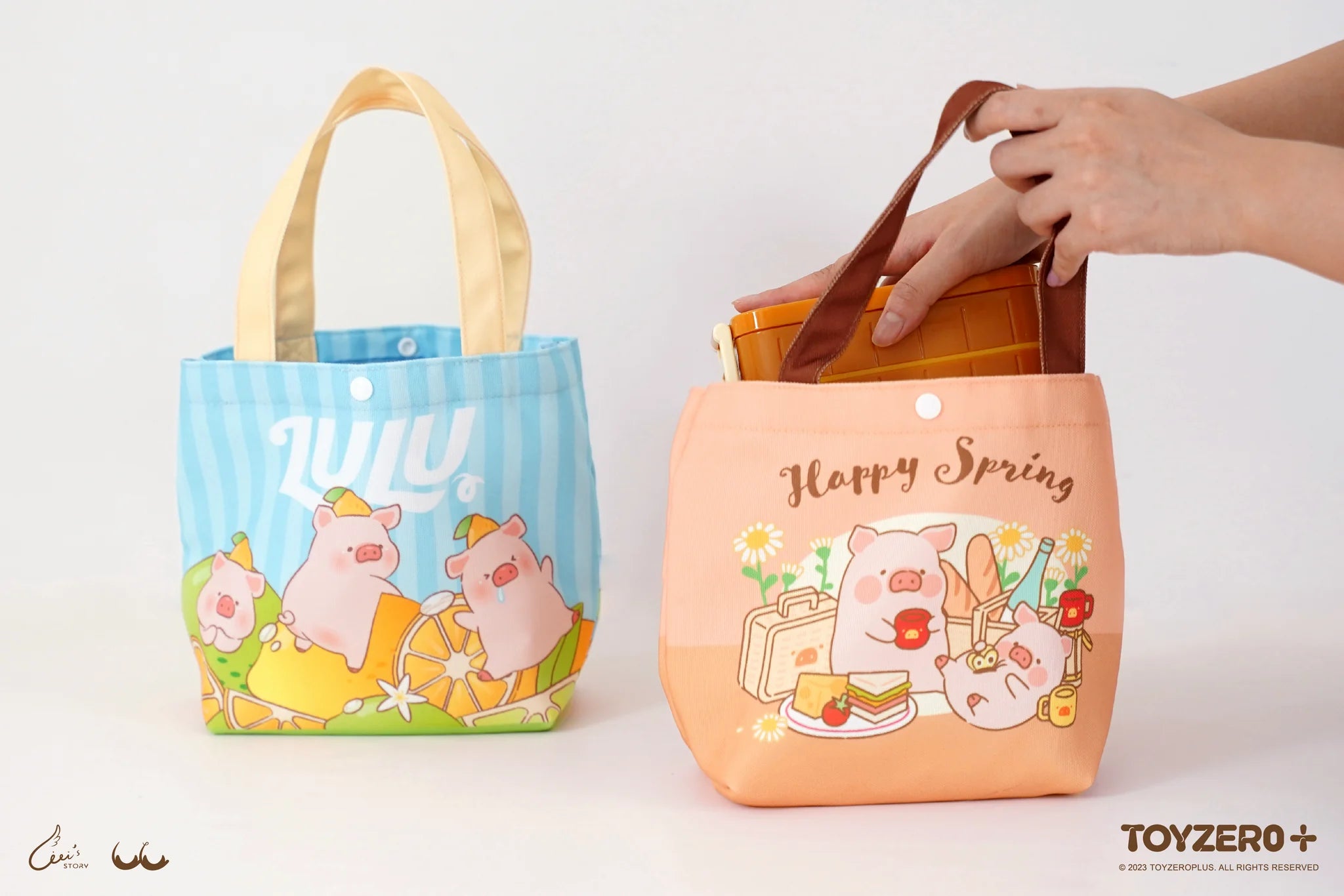 A hand holding LULU THE PIGGY lunch bag with cartoon pig design and a bottle of honey, flower detail visible.
