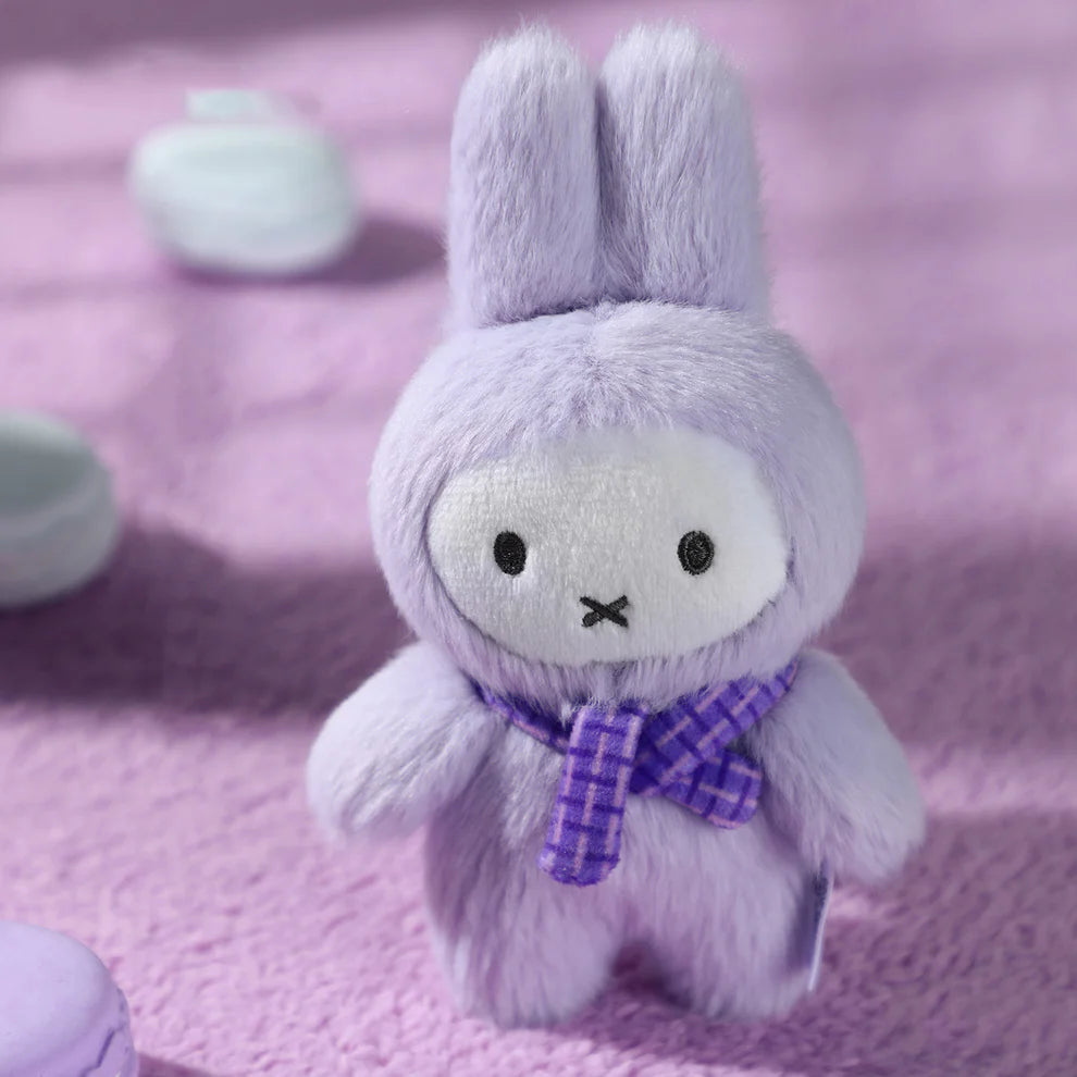 Miffy Macaron V2 Plush Keychain Blindbox features a lavender bunny plush with a scarf, amid pastel confections, offering 6 designs plus a secret option.