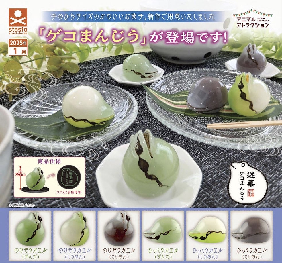 Geko Manju Gacha on a white plate, featuring a glass frog and brown object, part of Strangecat Toys' unique blind box collection.