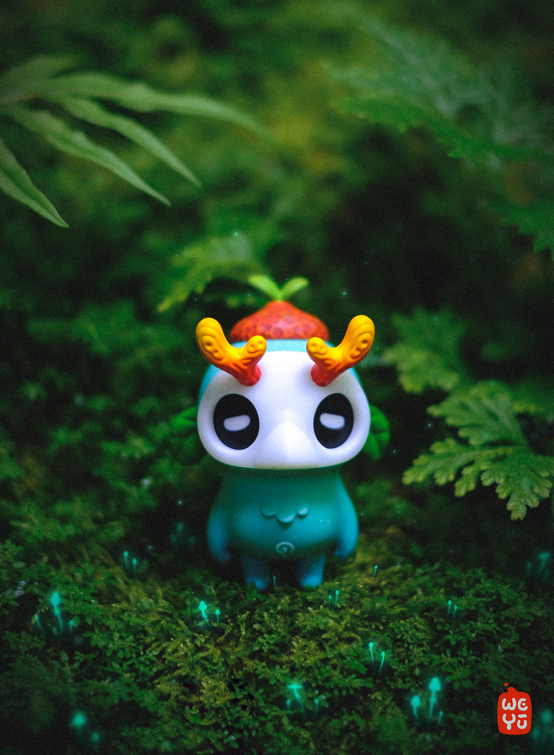 Ori Muffinn: The forest spirit vinyl toy with glowing eyes and mask, stands on moss with bioluminescent sprouts, featuring curled horns and a red cap.