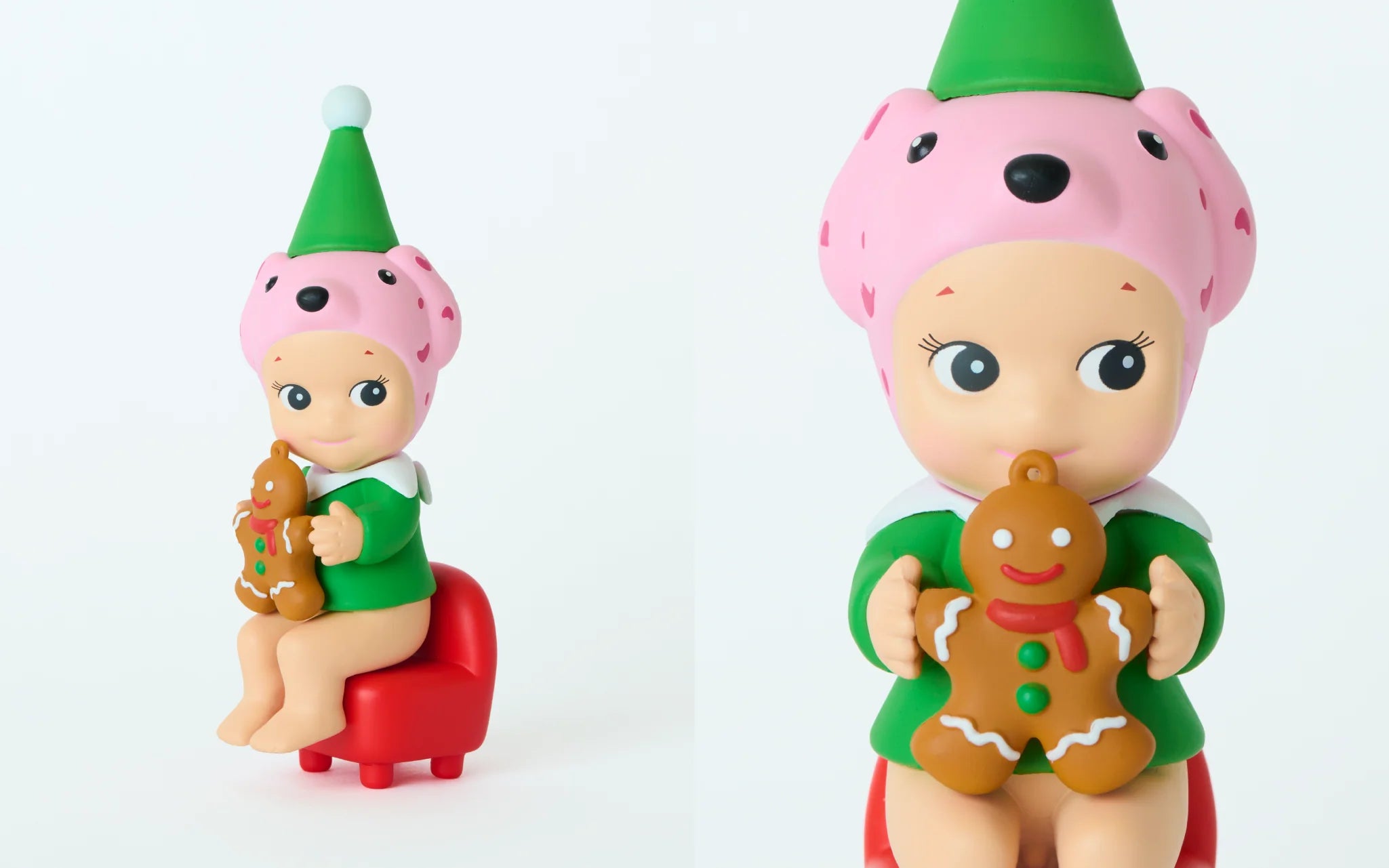 Sonny Angel figurine from Santa's Little Helper Series, wearing a pink dog hat with an elf cap, holding a gingerbread cookie while seated on a red stool.