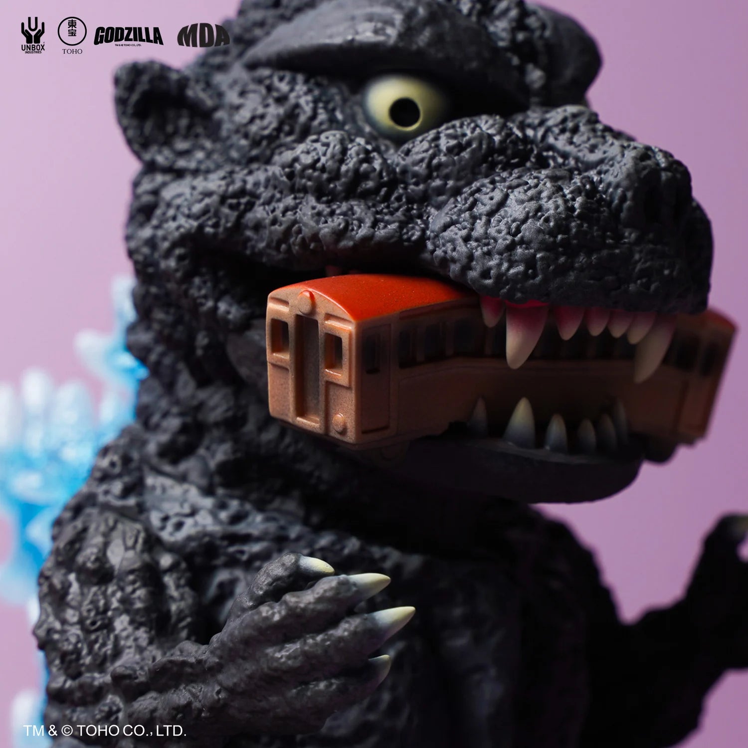 Godzilla 1954 MDA Project vinyl toy, black figure with train in jaws, featuring blue atomic breath detail, pre-order at Strangecat Toys.