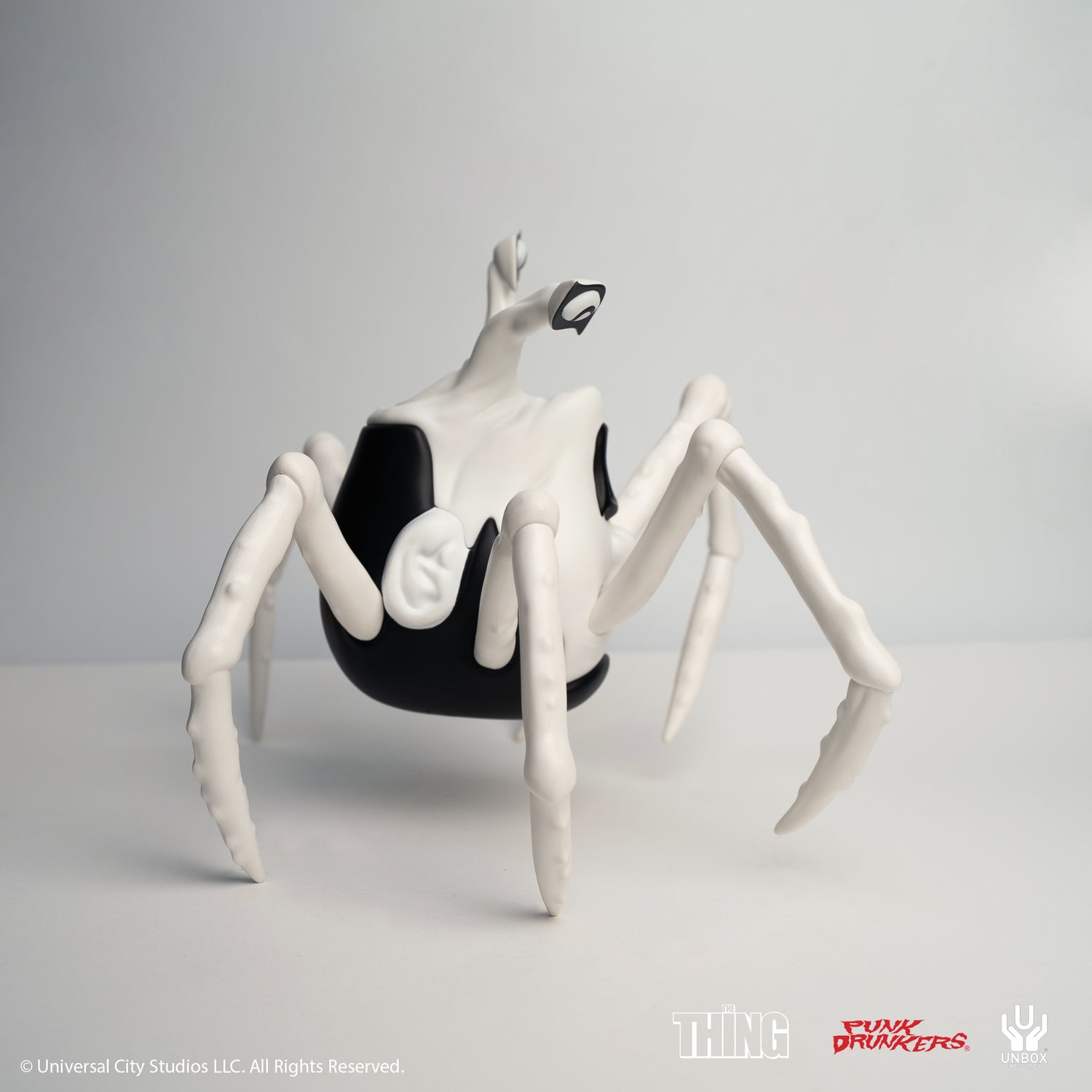 THE THING: PDS AITSU CHASE VARIANT HEAD - Preorder; a black and white vinyl figure, spider-like form, branded with Universal’s The Thing, Punk Drunkers, and Unbox.