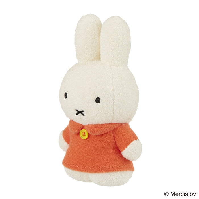 Tokotoko Club Miffy plush toy, white rabbit in an orange dress with a yellow button, minimalist design, standing upright, 17cm tall.
