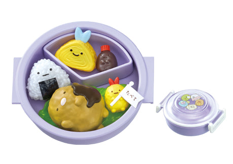 Sumikko Bento Re-ment Blind Box Series featuring toy-style play-food including a smiling onigiri, tamagoyaki, sausage, hamburger patty, and chick-shaped garnish in a purple container.
