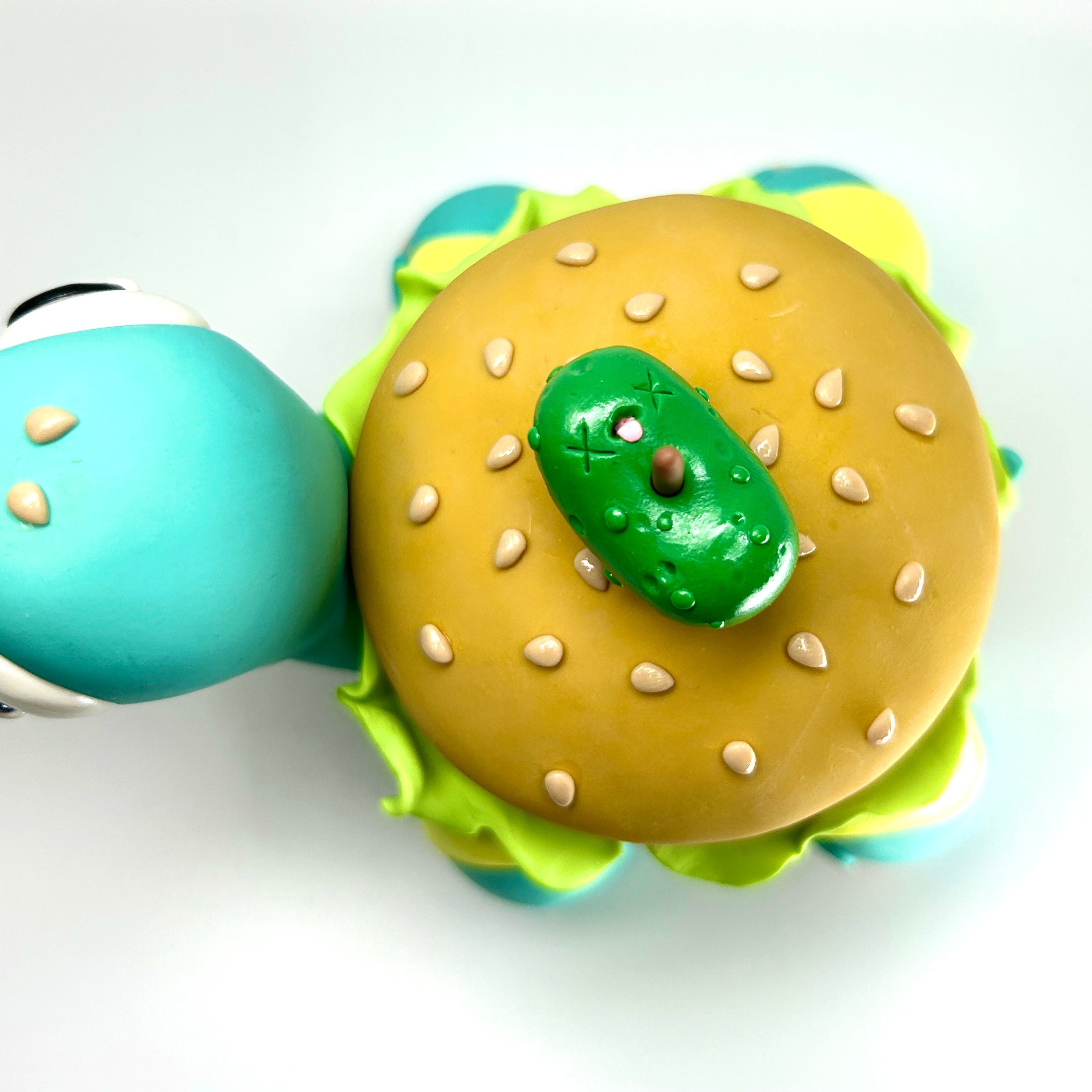 Toy turtle with a burger and pickle, part of Simon Says Macy & Friends - Turtleburger - Pastel Goth Remix.