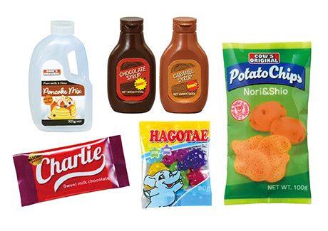 Members-only discount store COW'S MART Re-ment Blind Box Series featuring six packaged sweet snacks and toppings, including pancake mix, syrups, chips, chocolate, and gummy candies.