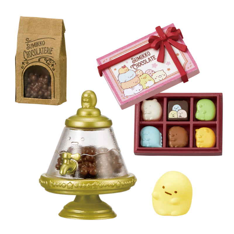 Sumikko Chocolaterie Re-ment Blind Box Series with chocolate-themed miniatures: kraft bag, dispenser, pastel chocolates, and Penguin? figure. Collect all eight designs.