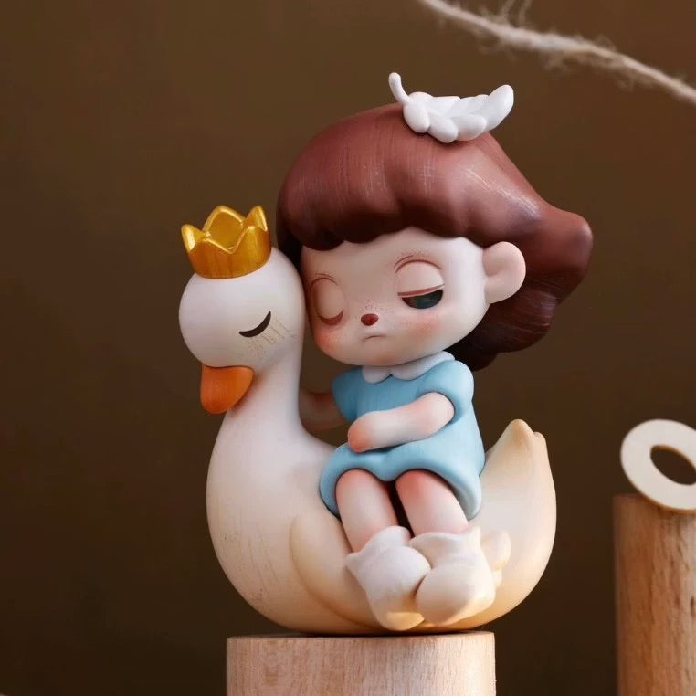 ANMOO Amo World is a Lie Fairy Tale Blind Box Series figurine of a girl sitting on a duck, available for preorder. Ships May 2025.