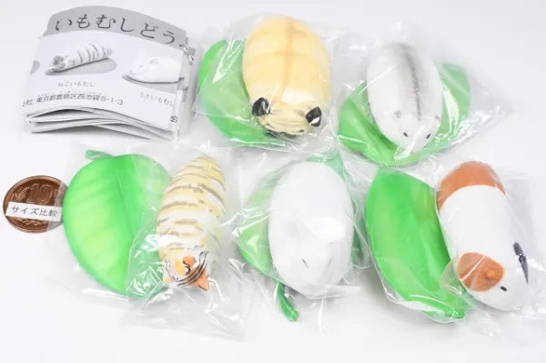 Very small Caterpillar animal Gacha Series: collectible toys shrink-wrapped on green leaves, next to a Japanese coin and pamphlet, showcasing variety and scale.