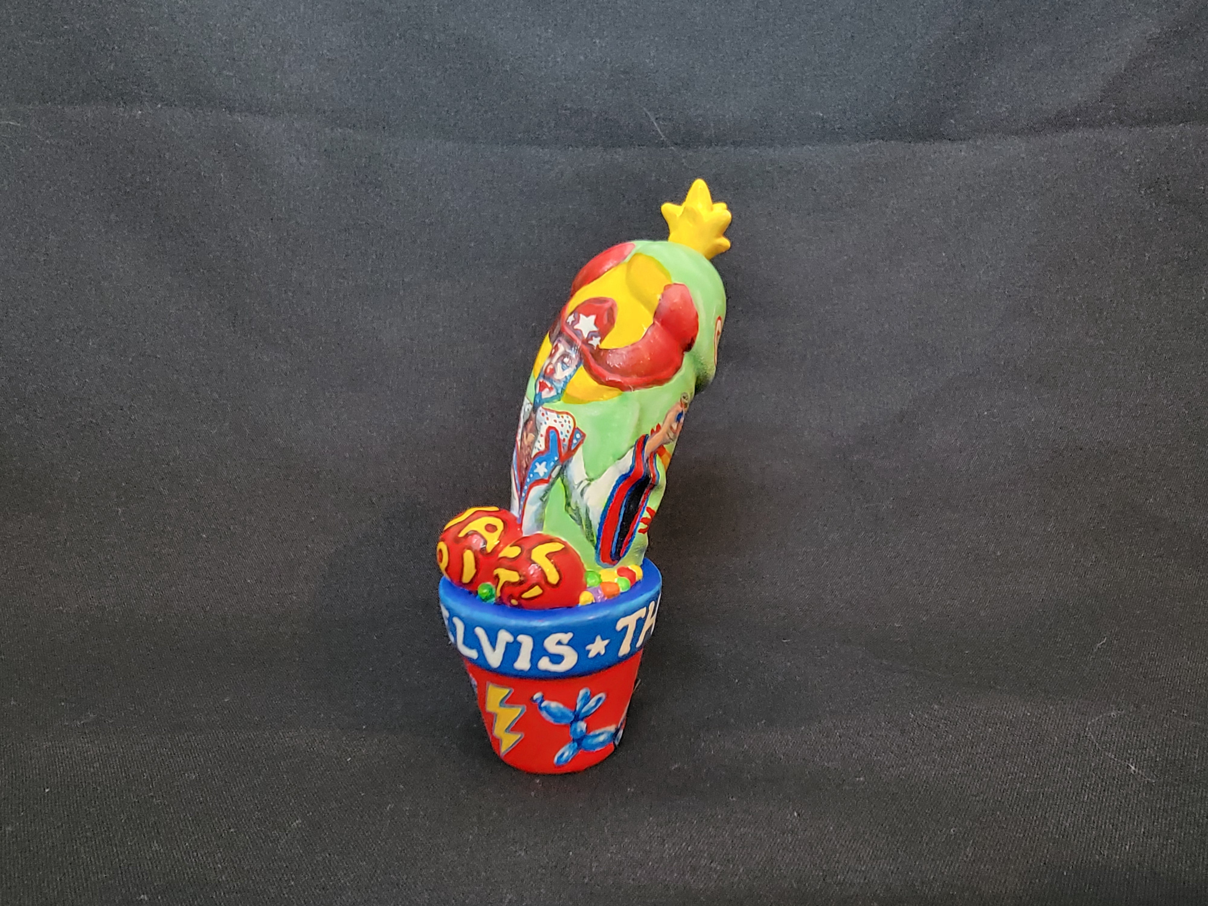 A colorful parrot figurine and clown statue with cactus and ceramic pot, part of Simon Says Macy & Friends collection by El Muerto Art.