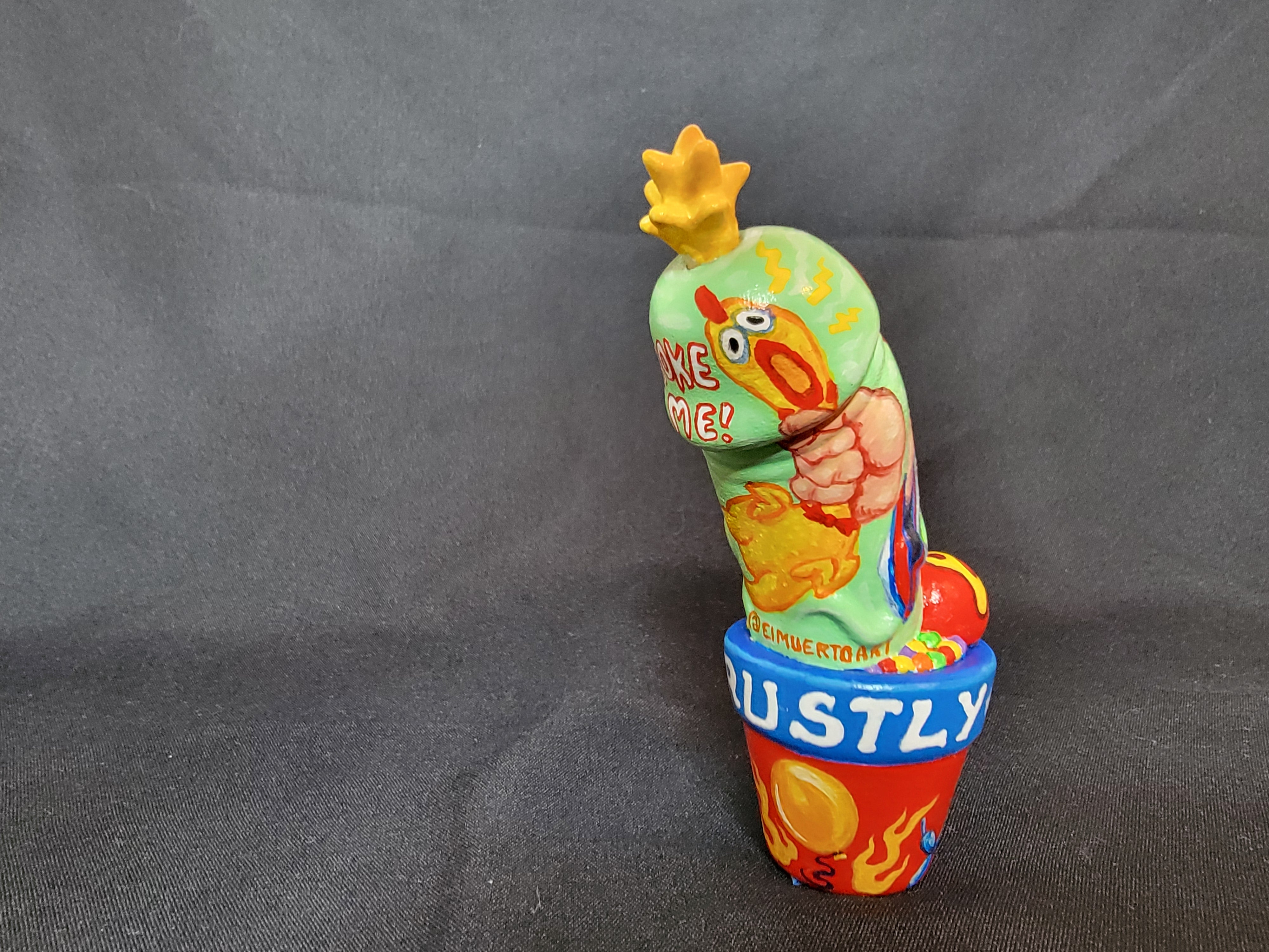 Toy chicken sculpture on surface, painted ice cream container, close-up of body and fabric, cartoon and fast food elements.