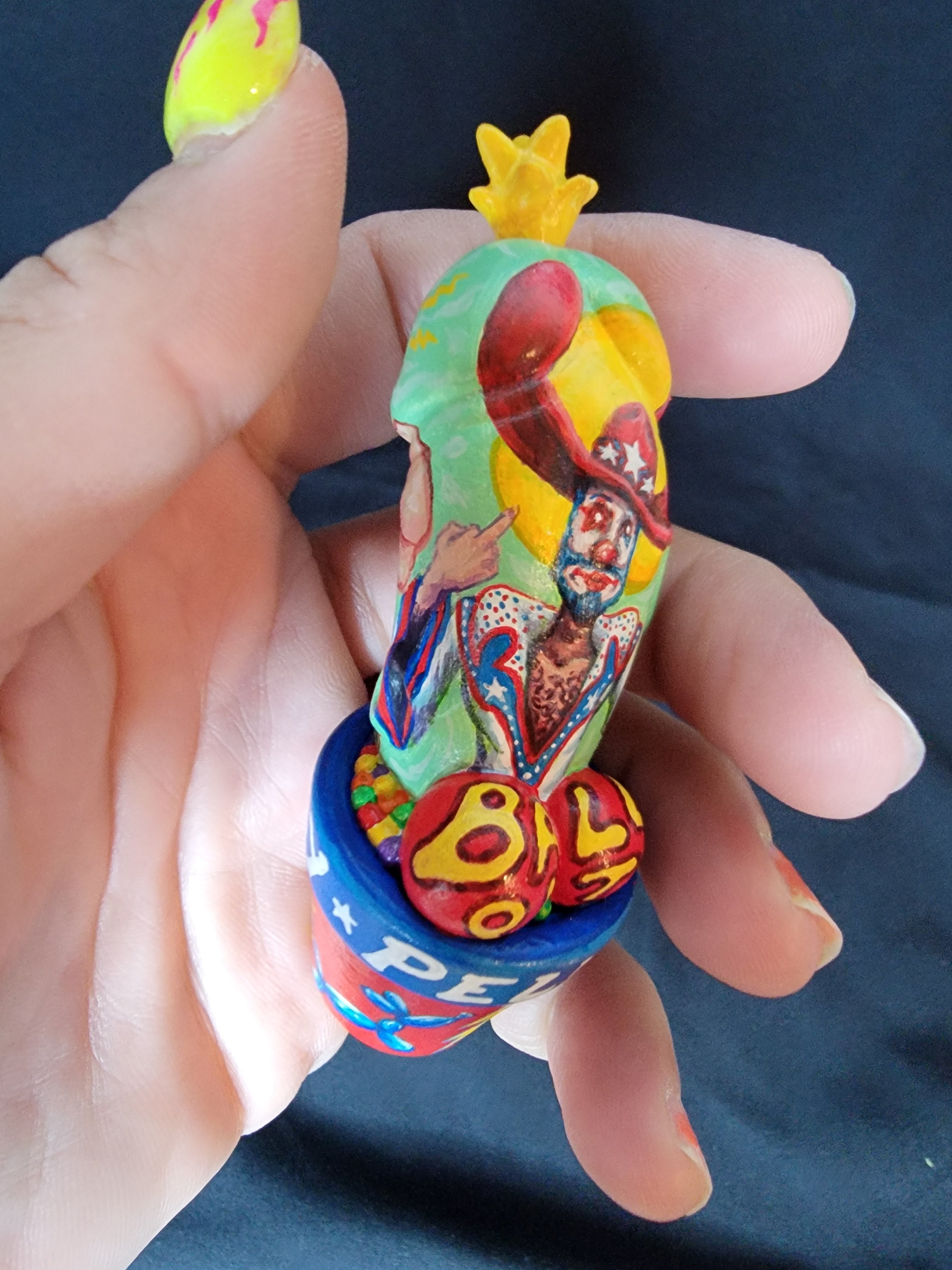 A hand holding a small figurine, toy, finger, person - Mixed media on PVC 3.5 Custom on Original Design by Simon Says Macy & Friends - The Great Pelvis Thrustly By El Muerto Art.