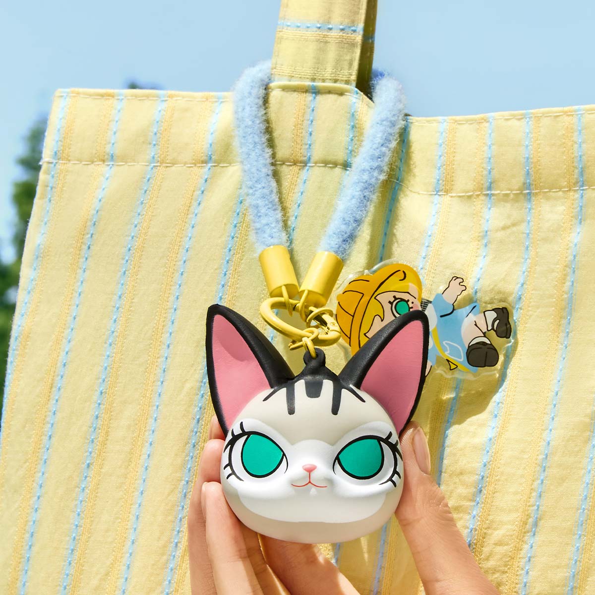 Baby Molly & Baby Tabby Series-Pinch Pendant Blind Box featuring a cartoon cat face keychain, crafted from PU foam and acrylic, held in hand.