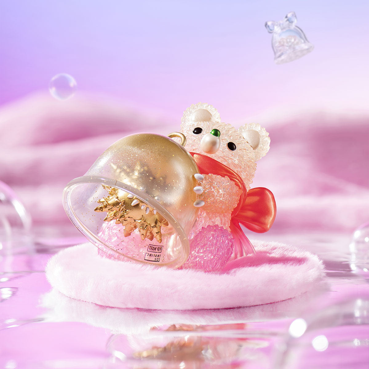 INSTINCTOY Muckey Celebration gift Series Figure: a crystal-textured bear with a red-orange bow, holding a glitter-filled dome, on a pink cushion.