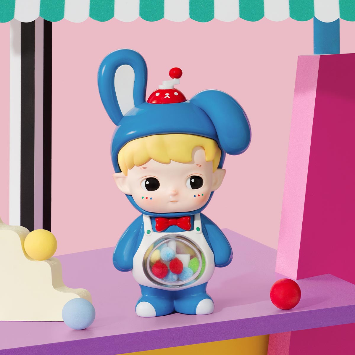 HACIPUPU Rolling Time Machine Series figure in a blue bunny suit with a gumball belly, displayed with geometric blocks. Preorder for August 2025.