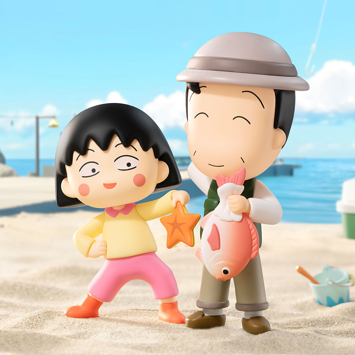 Chibi Maruko Chan's The Time With You Series Figures depicting a seaside scene with cartoon characters, featuring a girl with a starfish and a man with a fish.