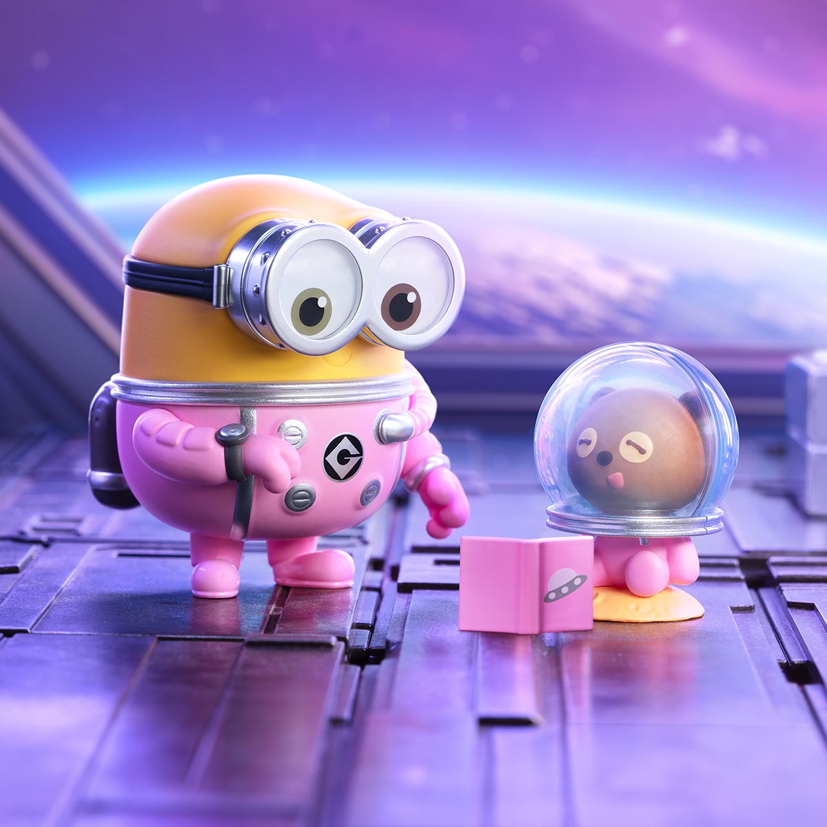 Minions Bedtime Stories by Bob and Tim Series Figures: A yellow Minion in a pink spacesuit and goggles, with a space-themed companion and book, set on a spaceship deck.