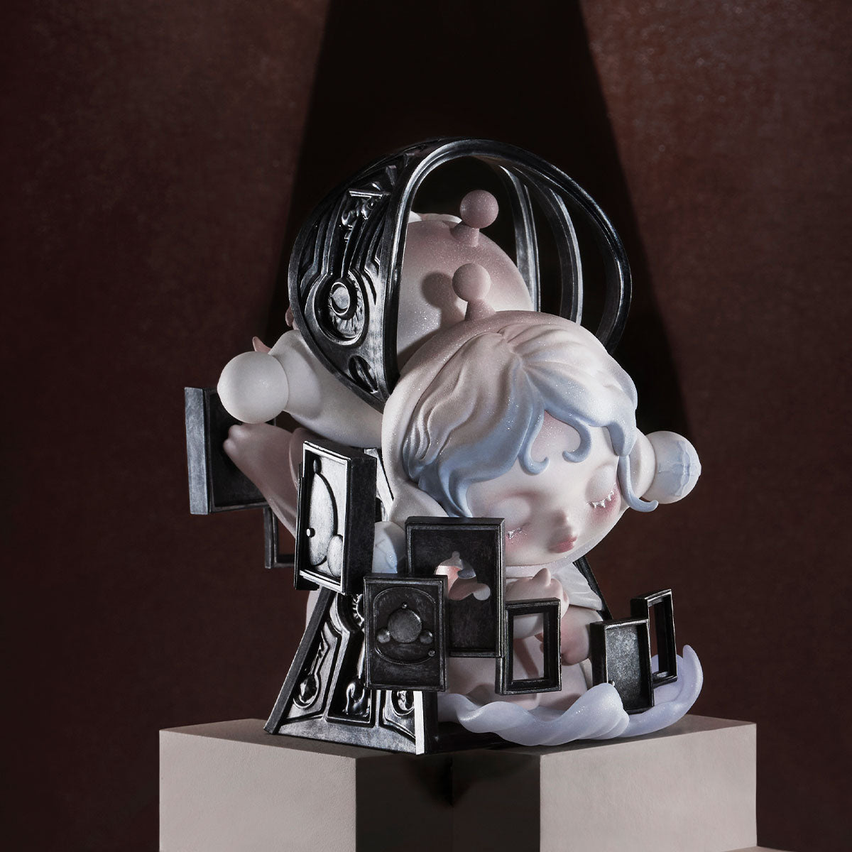 SKULLPANDA The Paradox Series Figure on a pedestal, featuring a sleeping face, metallic cage helmet, and floating frames, offering a dreamlike, modern aesthetic.