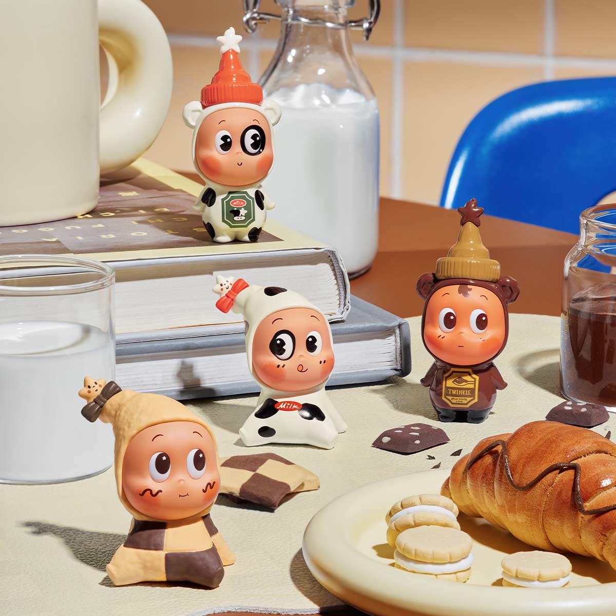 Twinkle Twinkle Create Your Taste Series Figures - Preorder: Four cartoon figurines in cow and pastry outfits, surrounded by milk, coffee, a croissant, and cookies in a playful scene.