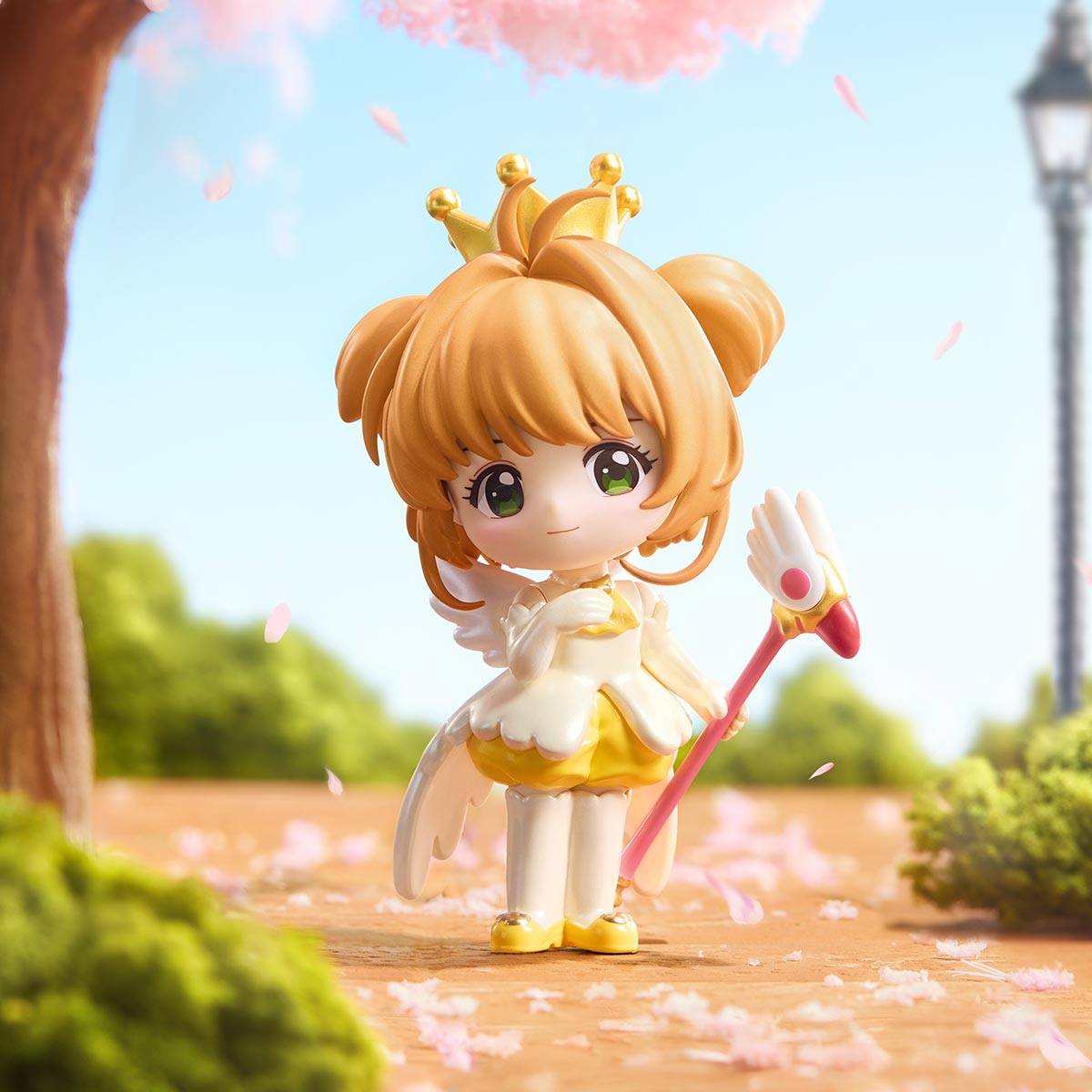 Cardcaptor Sakura: Clear Card Series chibi figurine in yellow dress with wings, crown, and pink staff, set beneath a cherry-blossom tree. Preorder for September 2025.