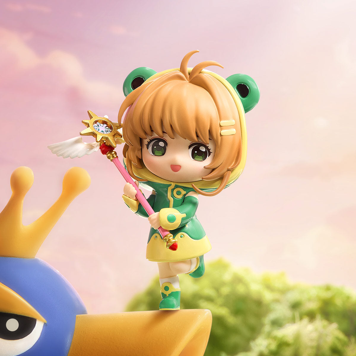 Cardcaptor Sakura: Clear Card Series Figures - Preorder features a chibi girl in a frog hood, dancing on a crowned star with a pink magic staff.