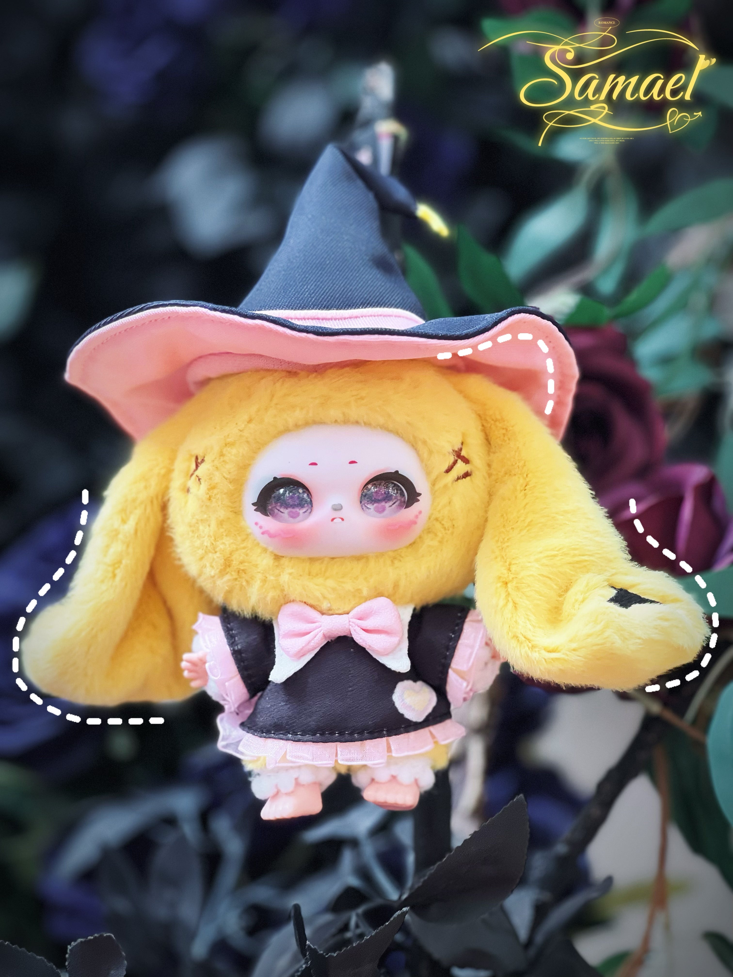 Baby Three - Shamali Magic Wardrobe plush doll, featuring bunny ears, a porcelain face, and a witch outfit, set against a dark foliage and roses background.
