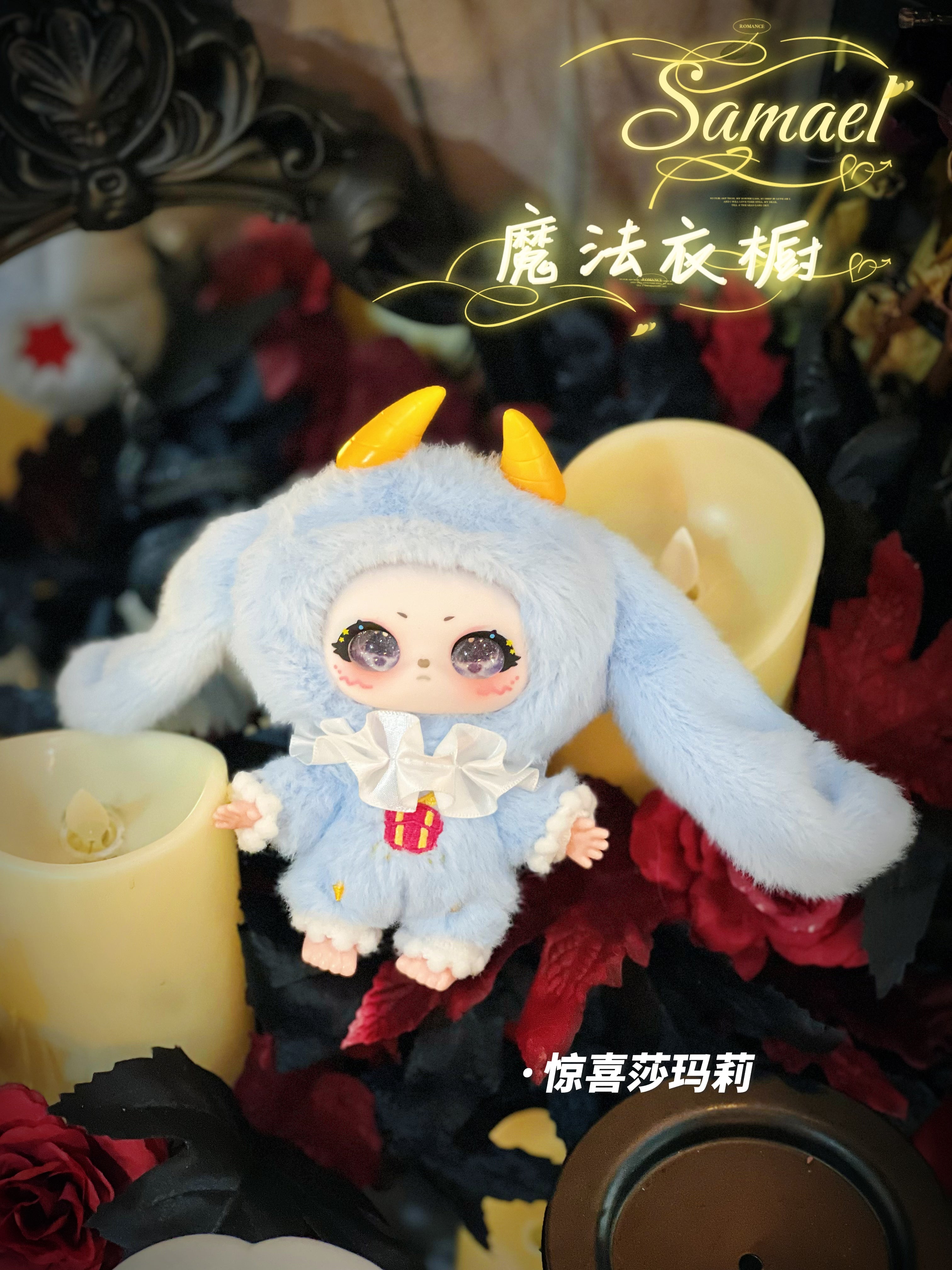 Baby Three - Shamali Magic Wardrobe doll in a blue onesie with floppy ears and horns, posed with faux candles and flowers; preorder at Strangecat Toys.