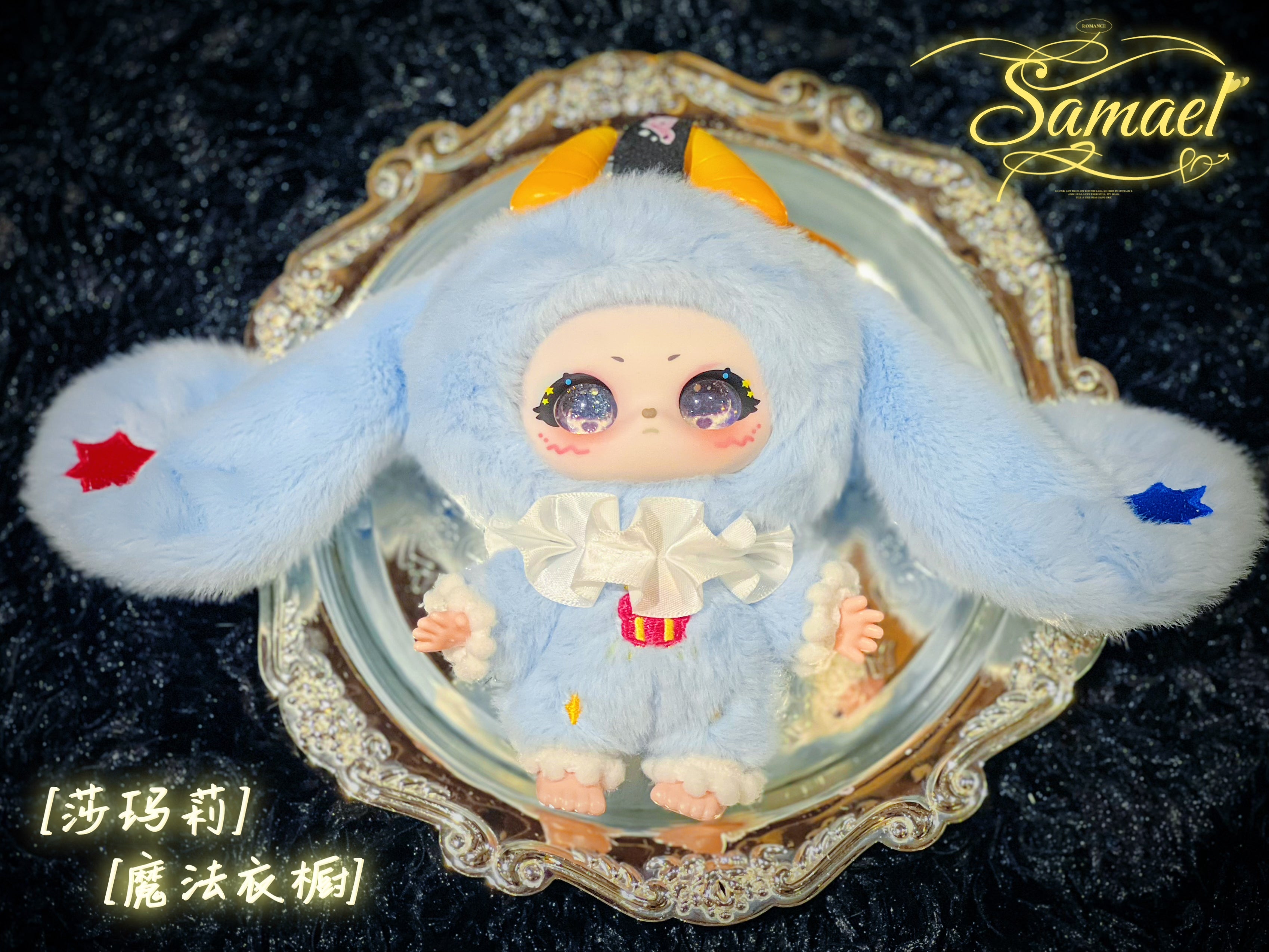 Baby Three - Shamali Magic Wardrobe plush-doll: pastel-blue bunny-hybrid with horns, oversized ears, galaxy eyes, in fluffy suit on silver tray. Preorder for October 2025.