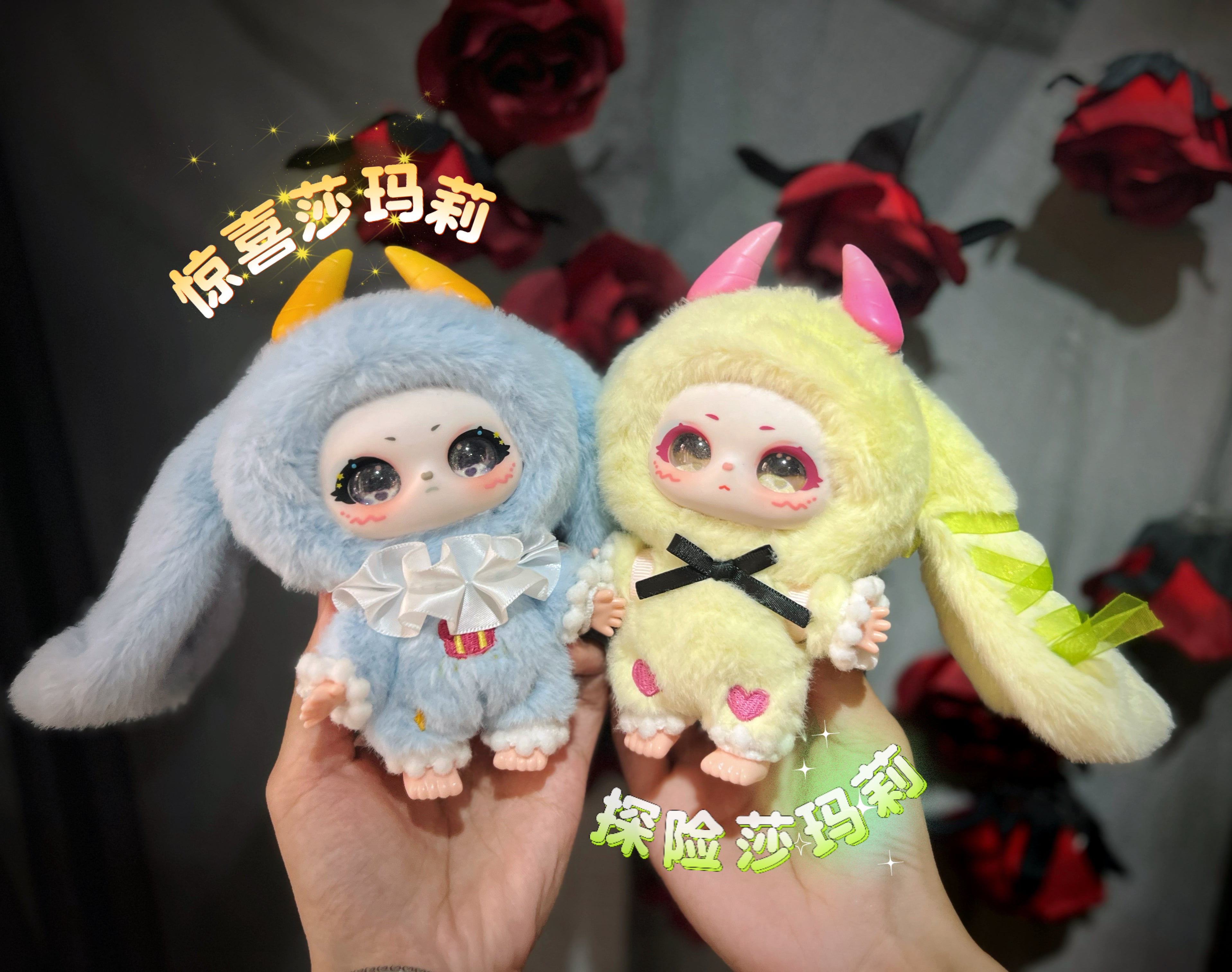 Two collectible dolls in animal onesies, part of Baby Three - Shamali Magic Wardrobe series, featuring glittery eyes, ruffled collars, and unique horn designs.