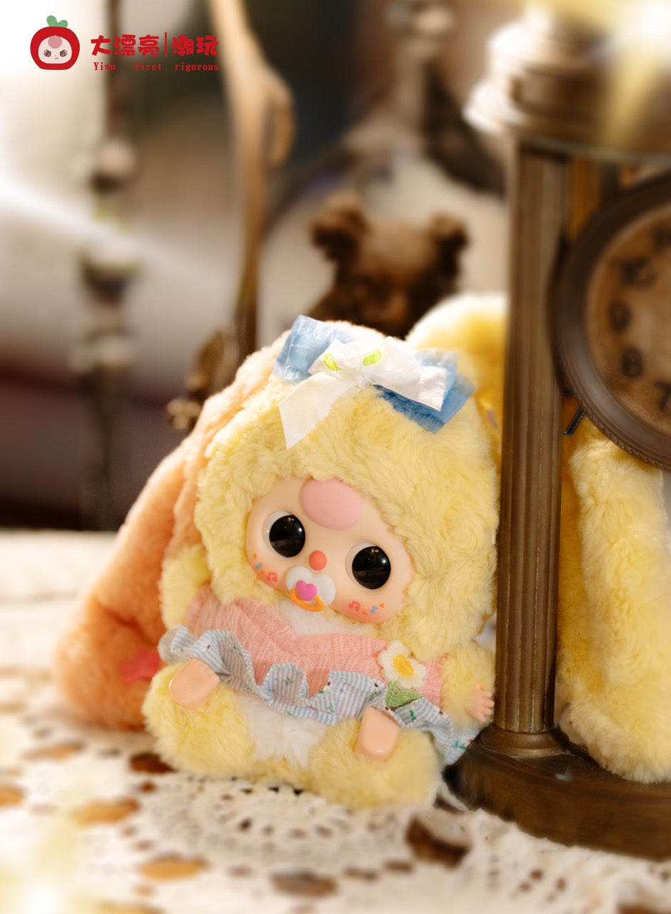 Kawaii-style plush doll Baby Three - Lily Rabbit Town 4 with yellow fur, pacifier, pastel ruffles, on lace doily near vintage clock, logo visible.