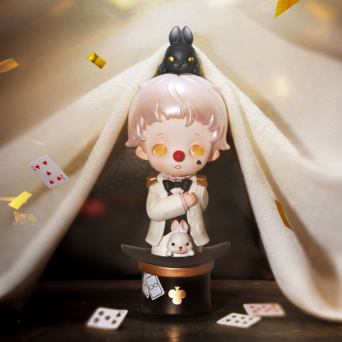 inosoul The Forgotten Land Series Figures - Preorder shows a magician-clown in a top hat with rabbits, playing cards, and confetti under a stage-like drape.