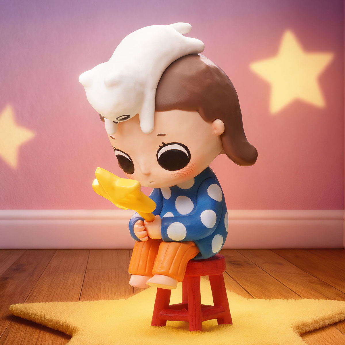 Nyota We are All Stars Series figurine: a child with a star wand and white creature, seated on a red stool, set for preorder.