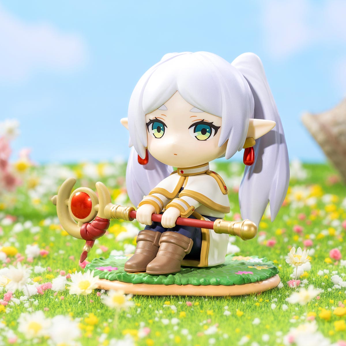Chibi-style elf figurine from Frieren: Beyond Journey's End Series, featuring lavender hair, a staff, and seated on a grassy base. Part of a blind box collection.