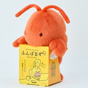 Bright-orange plush character with antennae atop a yellow box, featuring illustrations and Japanese text. Posture Pal - Marine supports posture at your desk.