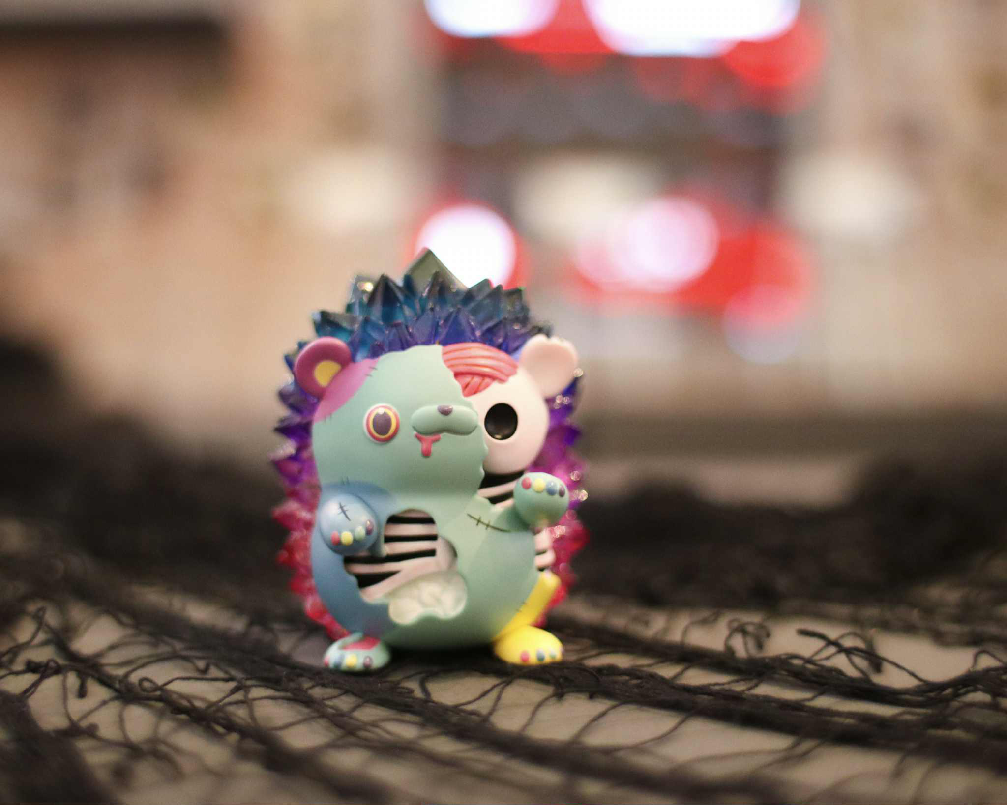 Spooky Zombie Hogkey by Tangent - Preorder. A stylized 8 cm resin art-toy, depicting a spiky hedgehog with a cartoon skeleton reveal, seated on black fabric.