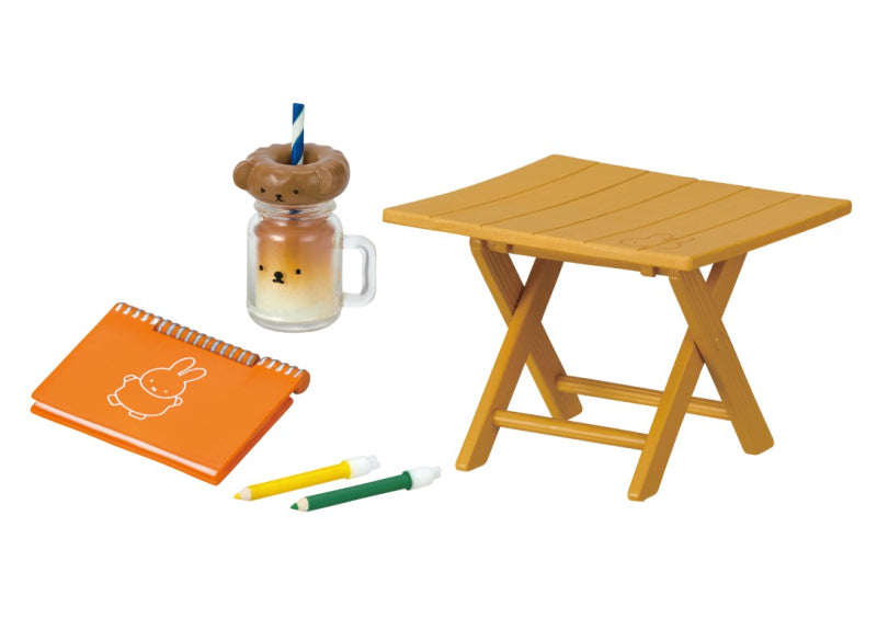 Picnic with Miffy Re-ment Blind Box Series featuring a glass mug with a bear head and an orange notebook with a rabbit design on a table.