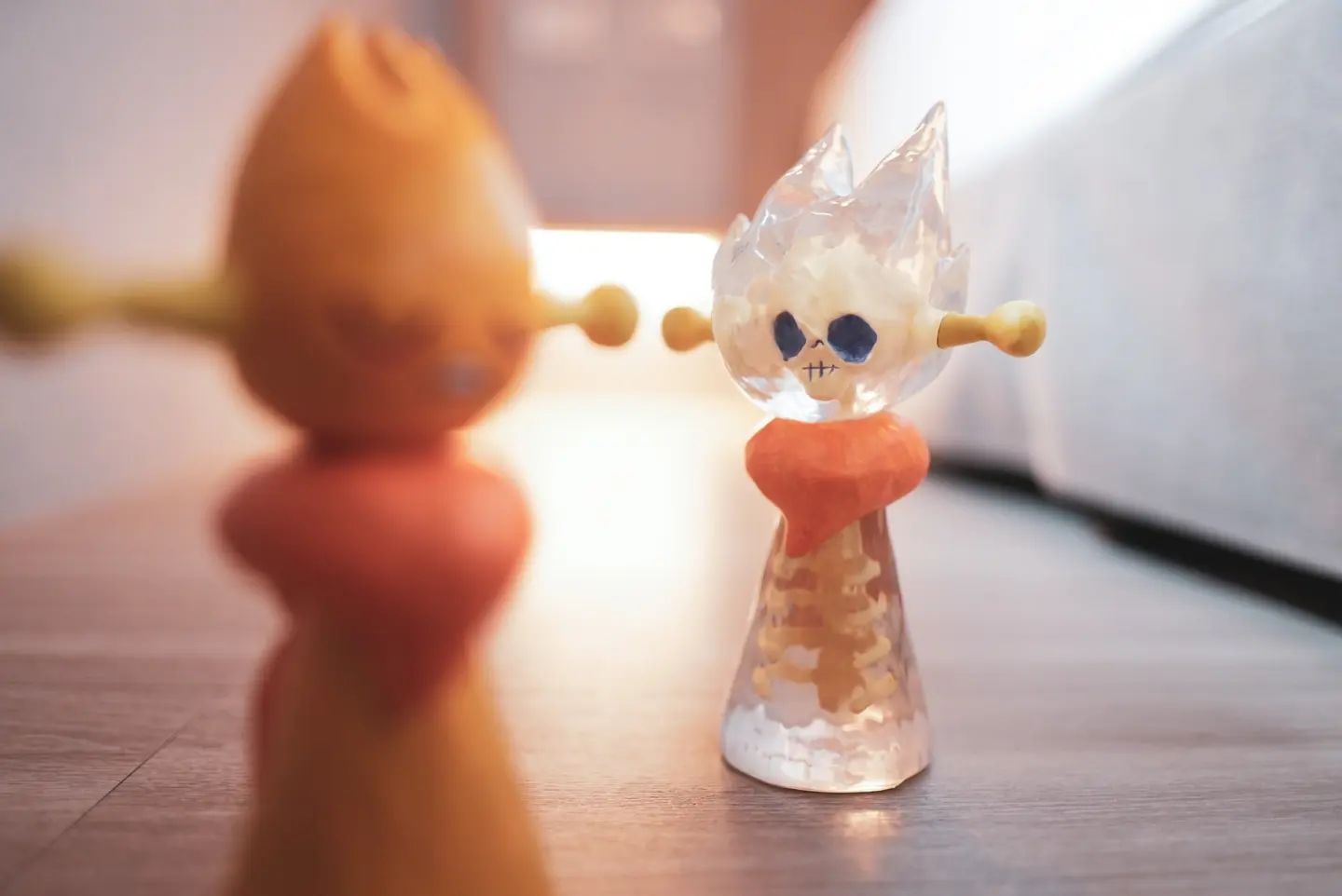 Resin figurine toy of Lucky Seijin - James (Secret) by JD Wang, with plastic toys and glass objects on a table.