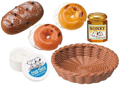 SNOOPY'S BAKERY Re-ment Blind Box Series features doughnut and bagel figurines with faces, displayed alongside containers and a jar, highlighting playful snack designs.