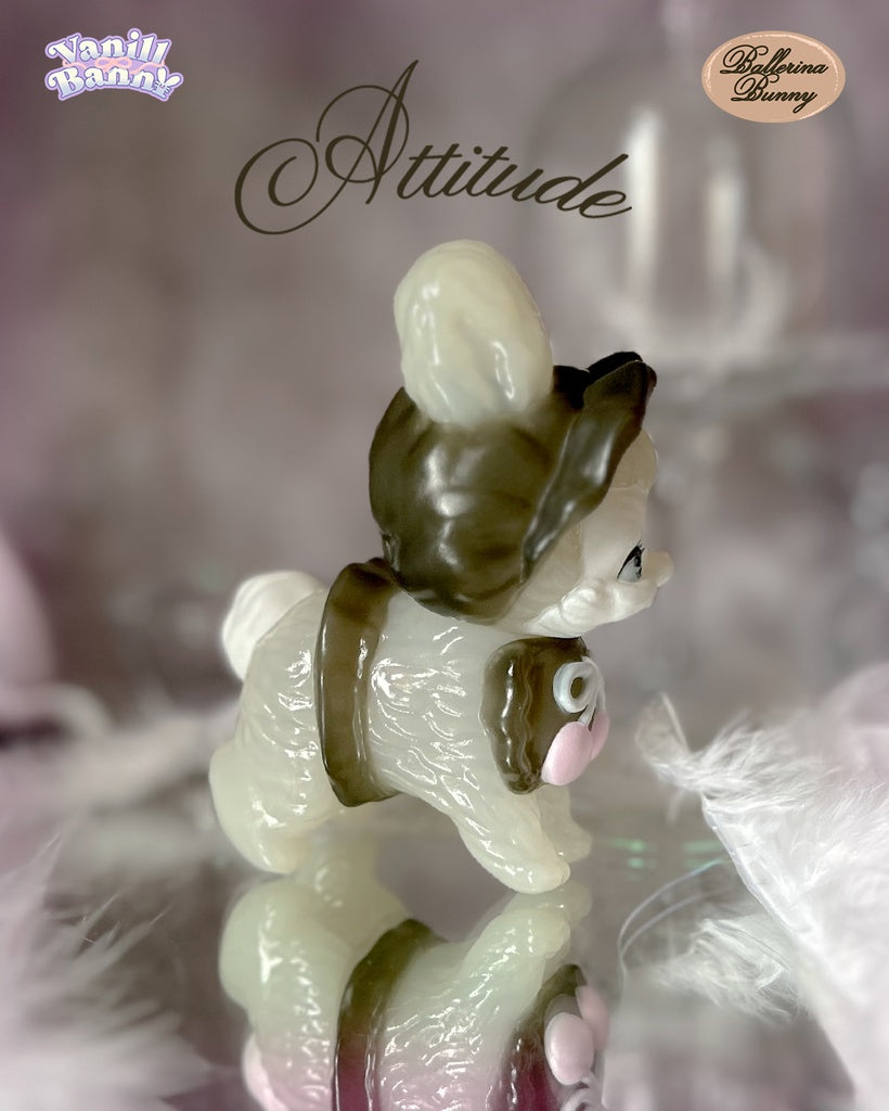 Vanill Banny - Ballerina Bunny by Ms LUTRA: A 130mm sofubi bunny figurine with a chocolate-brown helmet and pink-centered chocolate detail, displayed on a reflective surface.